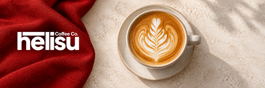 HELISU Coffee Co. – weißes Logo auf rotem Stoff neben Cappuccino mit Latte Art