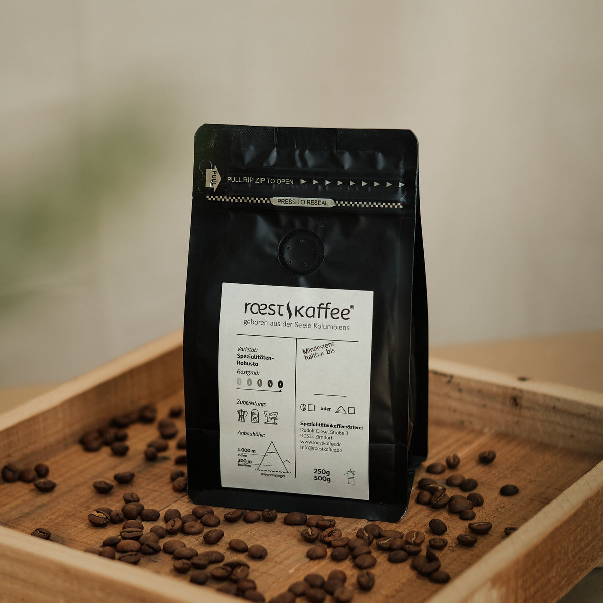 Eine 250g Kaffeepackung auf einem Holzbrett, Spezialitätenkaffee aus Brasilien und Indien mit Aromen von Zartbitterschokolade und getrockneten Feigen.