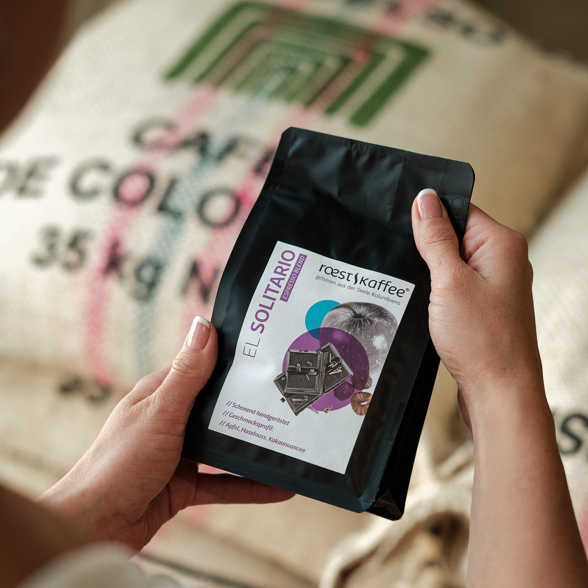 Eine Frau hält eine 250g Kaffeepackung in der Hand