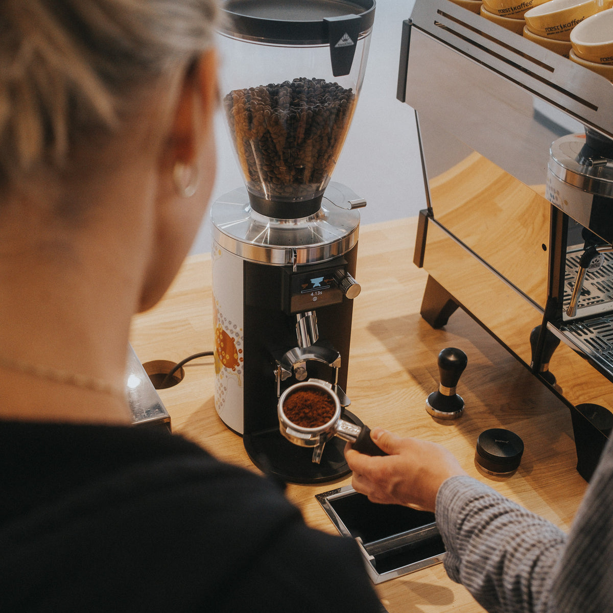 Teilnehmer schäumt Milch für Latte Art im Barista Beginner Workshop bei roestkaffee.