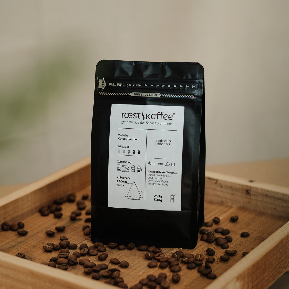 Eine 250g Kaffeepackung auf einem Holzbrett. Eine 250g Kaffeepackung auf einem Holzbrett.  Mit Aromen von sonnengereifter Orange, Schokolade und Nüssen 