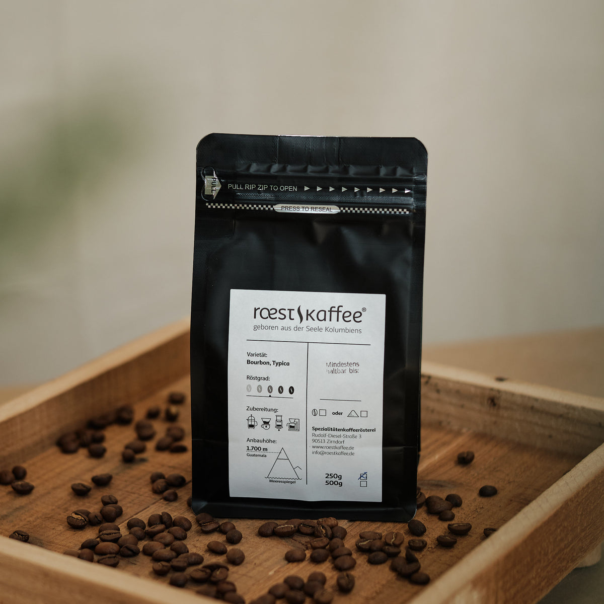 Eine 250g Kaffeepackung auf einem Holzbrett, aus dem nordwestlichen Guatemala. Mittel-dunkle Röstung mit einzigartigem Aroma von Orange, Schokolade und Ahornsirup